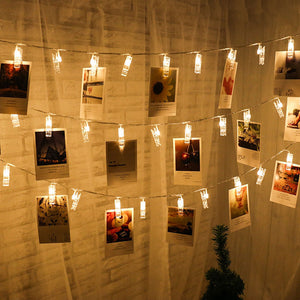 Gemütliche Schlafzimmer-Atmosphäre mit der Foto Lichterkette LED über dem Bett, Polaroid-Fotos in warmem Licht, ideal zur Schaffung einer persönlichen Galerie.