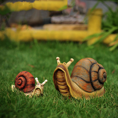 Deko Schnecke als wetterfeste Tier-Gartendeko im Blumenbeet zwischen Rosen und Lavendel