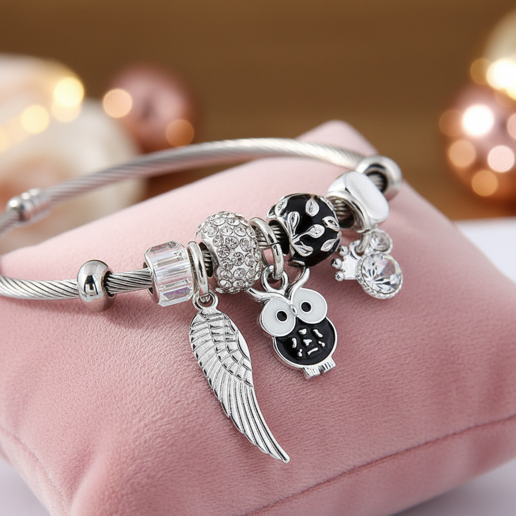 Charm Armband Engelsflügel Schwarz mit Eule und Kristall in Silber, symbolisiert Schutz und Weisheit.