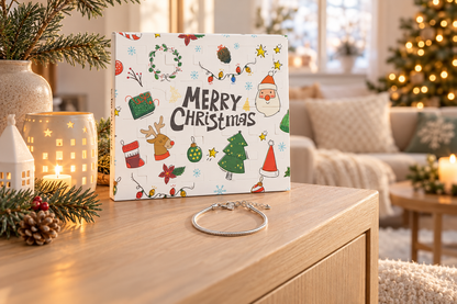 Merry-Christmas-Box aufrecht an einer Vase auf der Kommode, davor ein schlichtes silbernes Armband