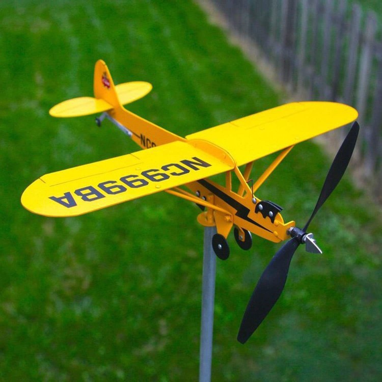 Gelbes Piper Cub Windrad Metall – Gartenstecker Windspiel von vorne auf Rasen