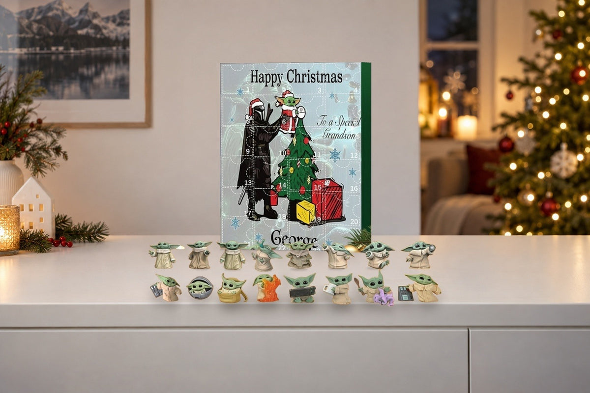 Baby-Yoda-Adventskalender mit Grogu-Figuren auf weissem Sideboard, Christbaum mit Lichtern im Hintergrund