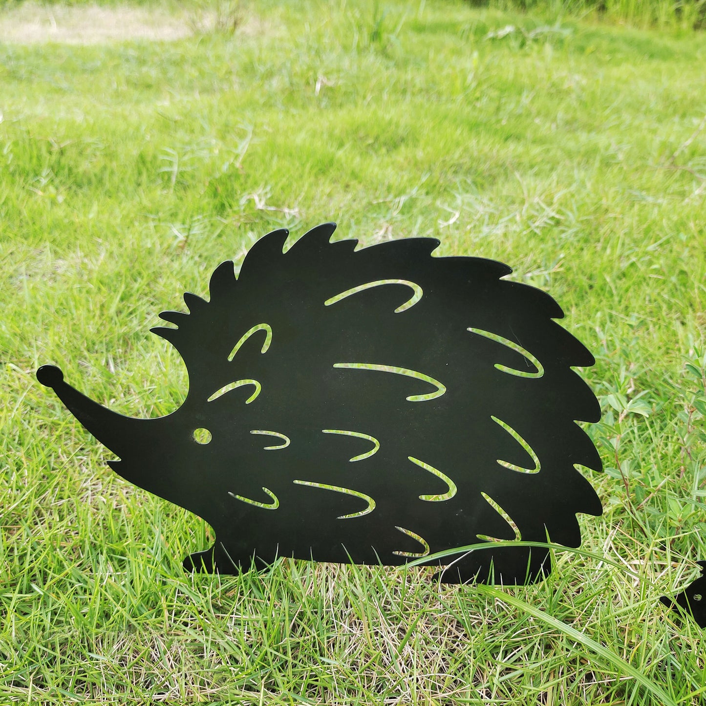 Kleine Igel-Gartenstecker aus Schmiedeeisen im Blumenbeet — herzige Gartendeko für Tierfreunde