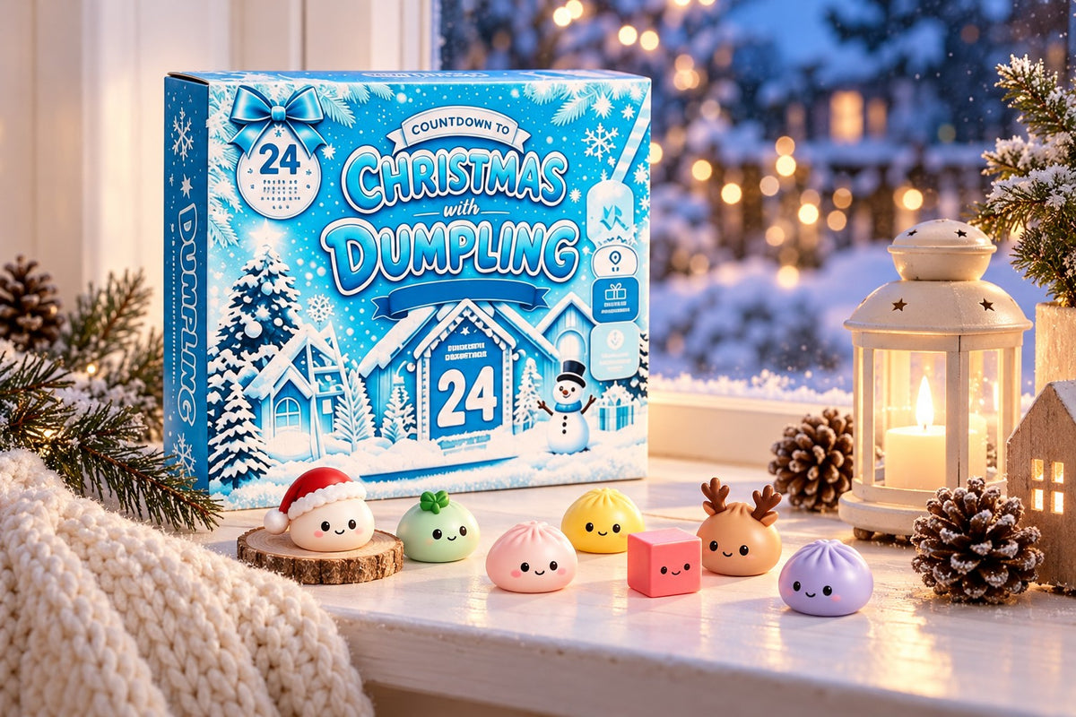 Dumpling Adventskalender Winterdorf: blaue Box mit verschneitem Dorf, davor Dumpling-Squishies und ein Squishy in Würfelform