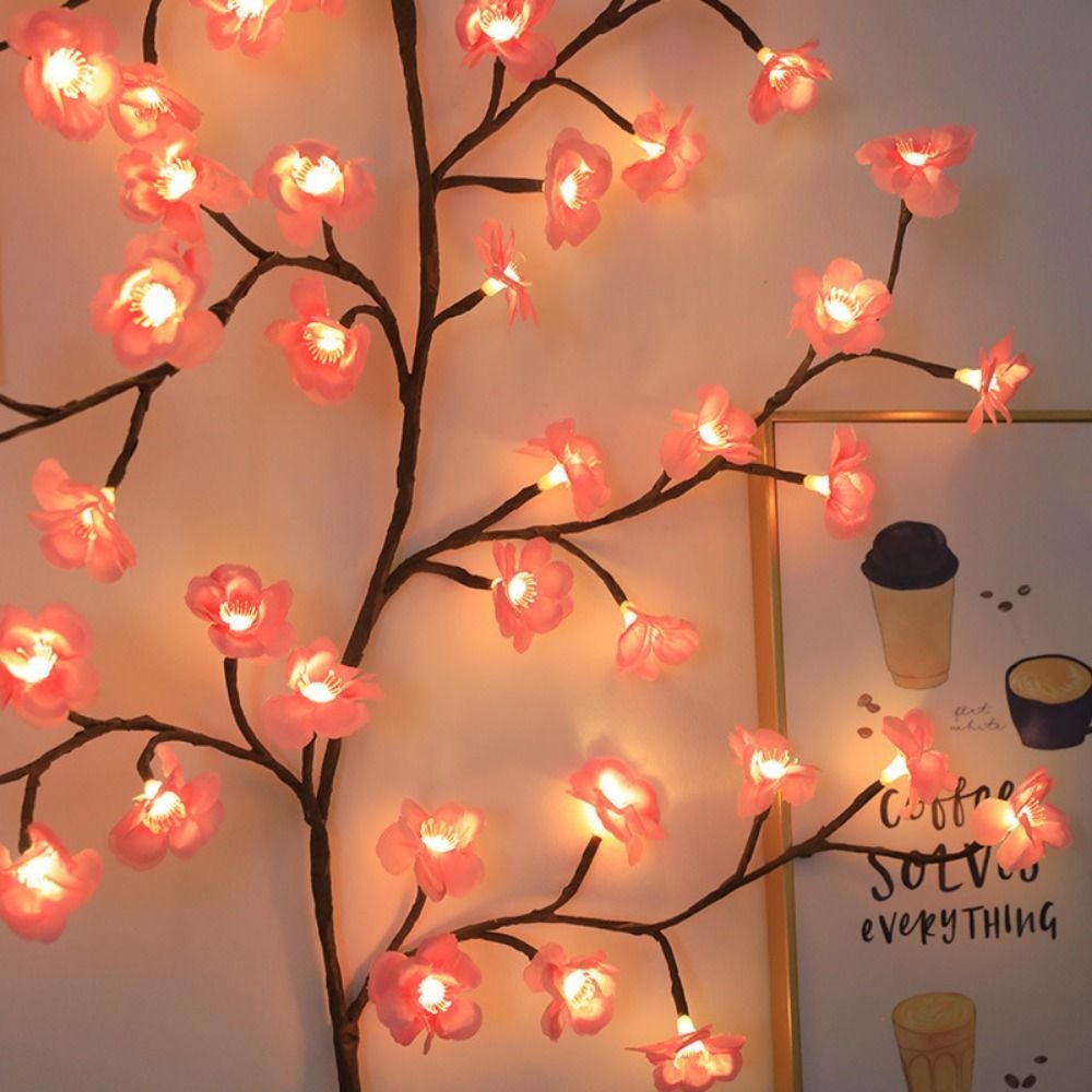 Nahaufnahme der rosa leuchtenden Kirschblüten mit LED am Zweig