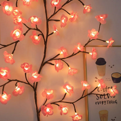 Nahaufnahme der rosa leuchtenden Kirschblüten mit LED am Zweig