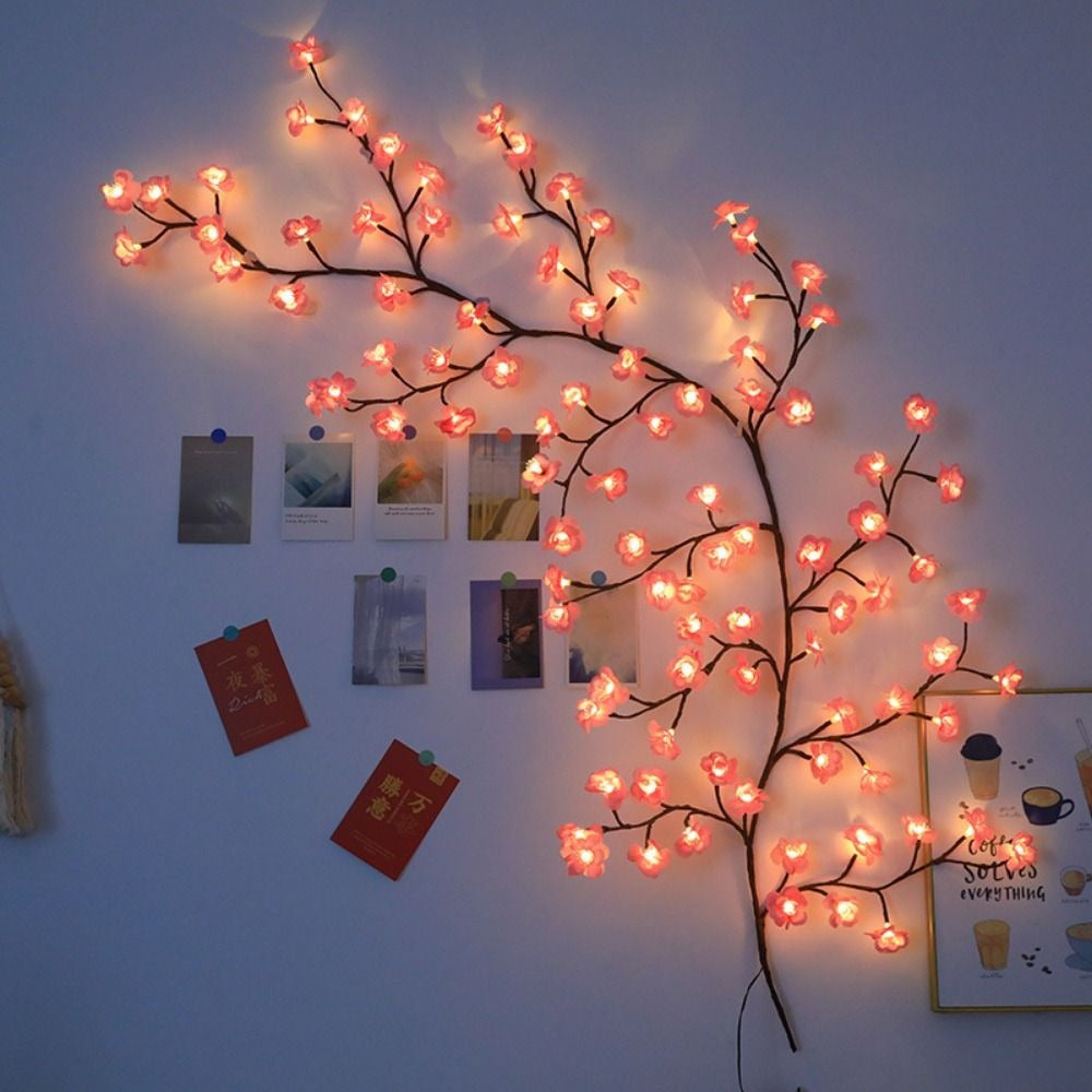 Kirschblüten Lichterkette an einer blauen Wand neben Fotos und Karten