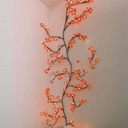Kirschblütenzweig mit LED senkrecht an der Wand neben einem Durchgang