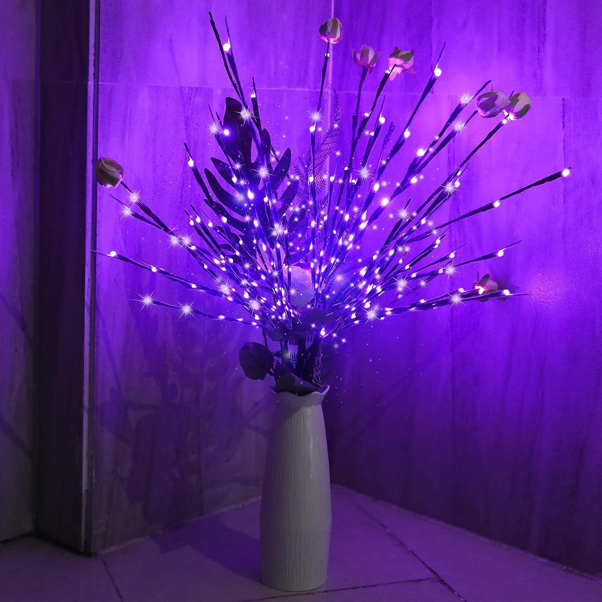 Dunkle Lichterzweige mit lila LEDs in einer hellen Vase