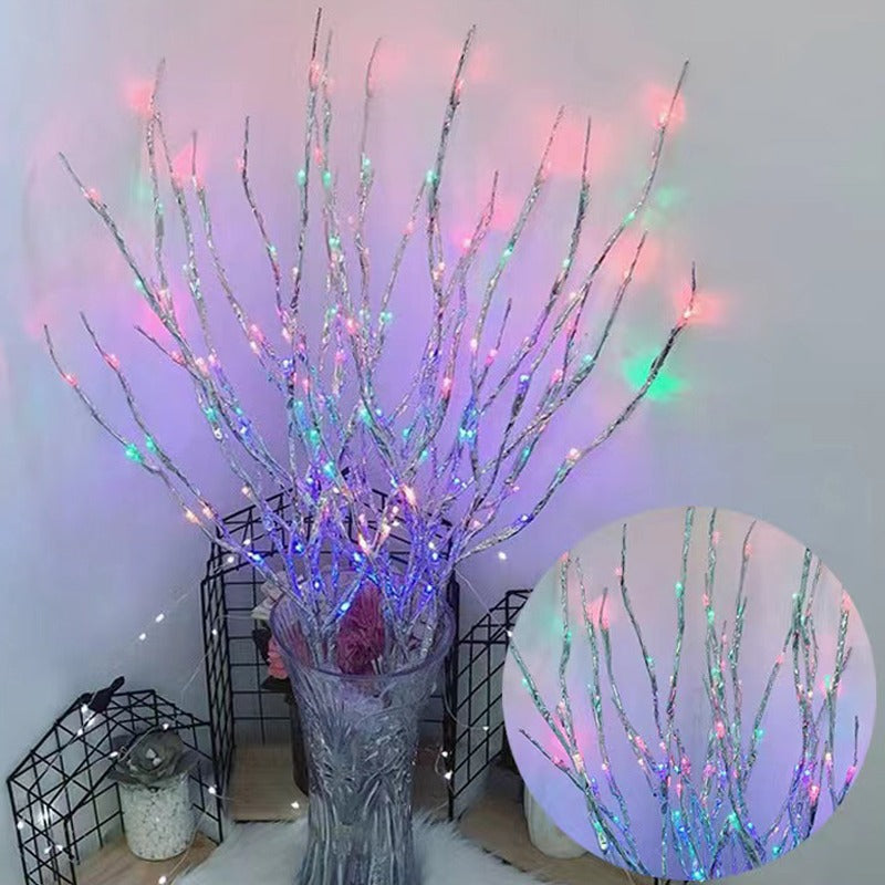 Silberne Leuchtzweige mit bunten LEDs in einer Kristallvase