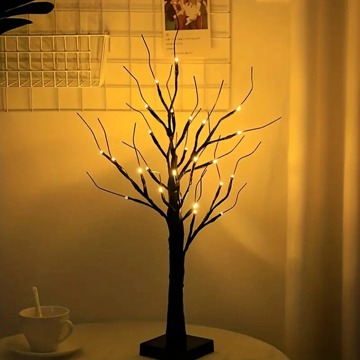 Schwarzer Lichterbaum mit 24 LEDs leuchtet warmweiss neben einer Tasse