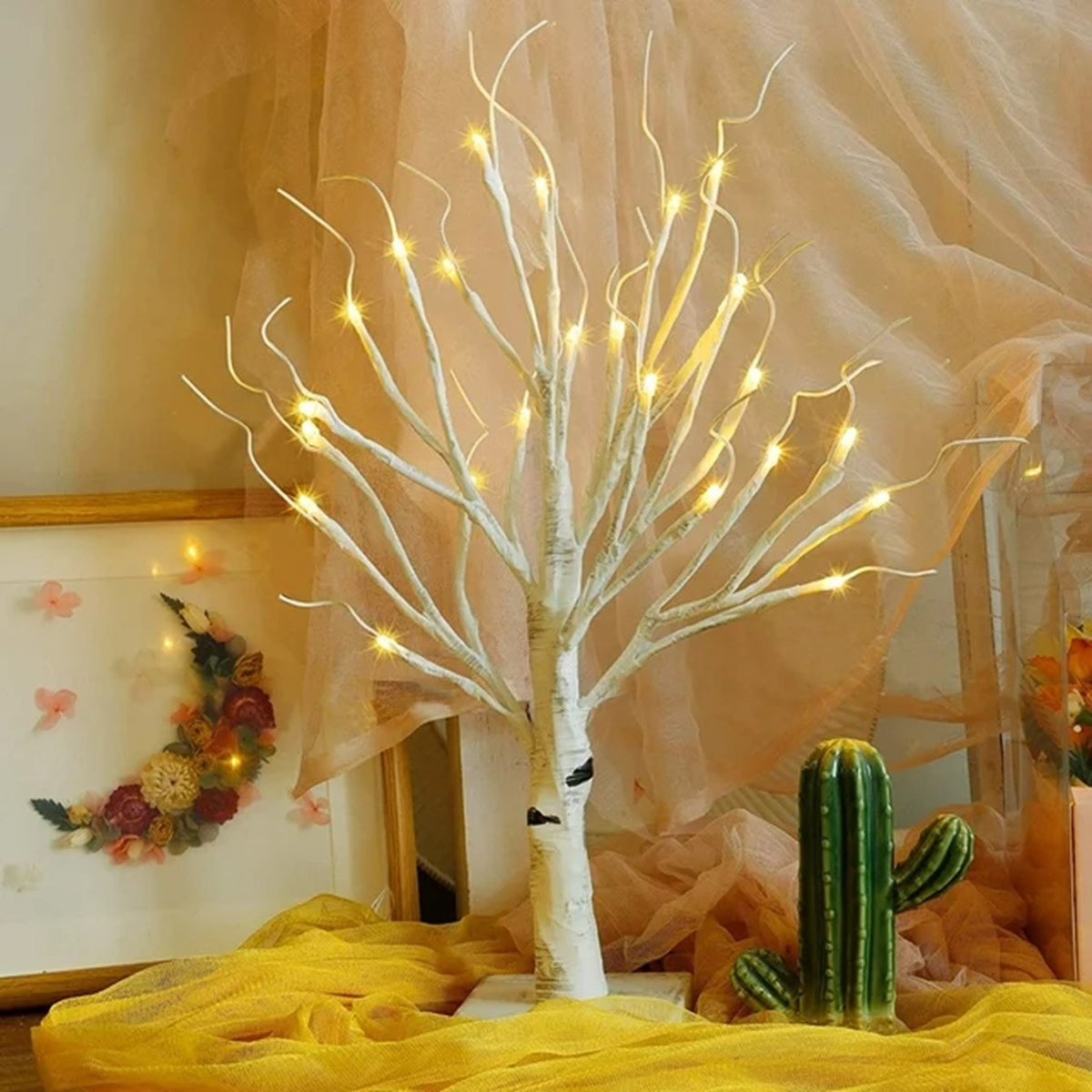 Lichterbaum Birke mit 24 warmweissen LEDs auf einer Kommode vor hellem Vorhang