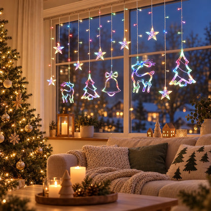 Bunte Lichterkette Vorhang mit Elch, Glocke und Tannenbaum am Wohnzimmerfenster über dem Sofa mit Kerzen