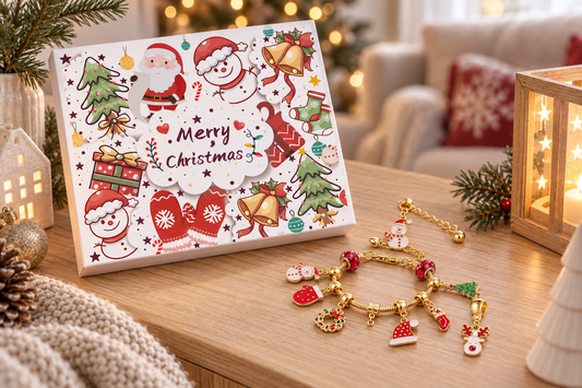 Bunte Merry-Christmas-Box auf einem Holztisch, davor liegt ein fertiges Armband mit roten Perlen und Fäustling