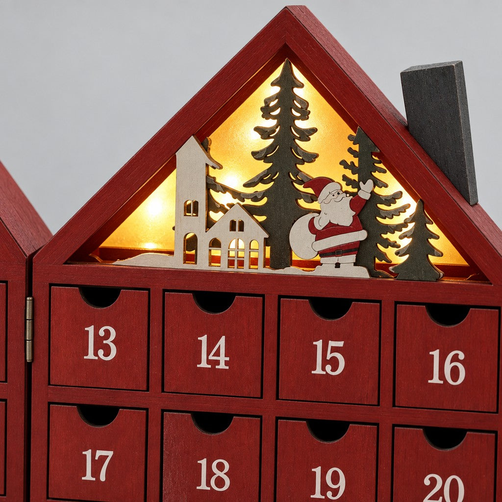 Detail: beleuchteter Giebel mit Tannen, Häuschen und Weihnachtsmann, darunter Schubladen 13 bis 20