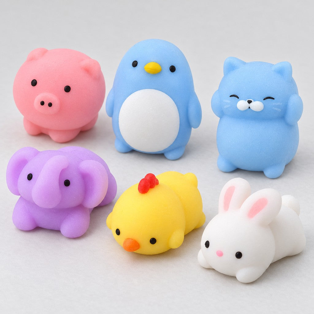 Nahaufnahme: weiche Mochi-Quetschtiere in Pastell, Schweinchen, Pinguin, Katze, Elefant, Küken und Hase
