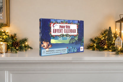 Superhelden-Kalender auf einem weissen Kaminsims zwischen Tannengirlanden mit Lichtern