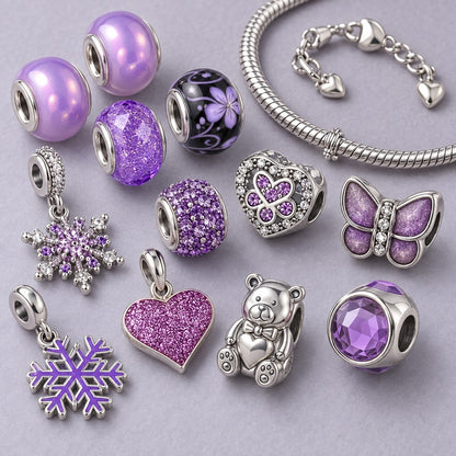 Fliederfarbene Glasperlen, Teddybär, lila Schmetterling, Glitzerherz und Schneeflocken neben einer Schlangenkette