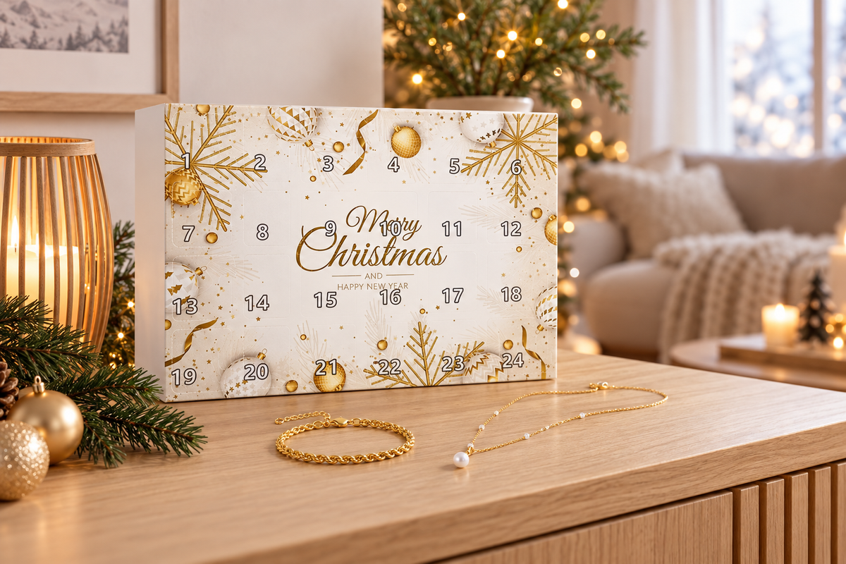 Kalender im Querformat auf einer Holzanrichte, davor eine gedrehte Goldkette und ein feines Kettchen mit Perle