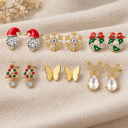 Sechs Paar Ohrstecker auf Leinen: Nikolausmütze, Schneeflocke, Kranz, Tannenbaum, Schmetterling und Tropfen