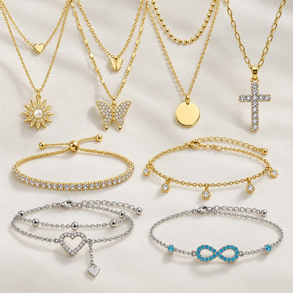 Vier Halsketten mit Sonne, Schmetterling, Plättchen und Strass-Kreuz über vier Armbändern in Gold und Silber