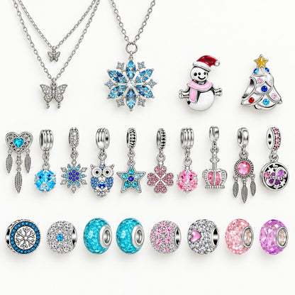 Einzelteile auf Weiss: Schmetterlingskette, Schneeflockenkette, Schneemann, Glitzertanne und Kristallperlen