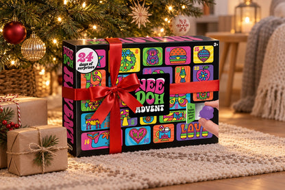 Schwarze Neon-Box mit rotem Band zwischen Packpapier-Geschenken, dahinter Christbaumkugeln